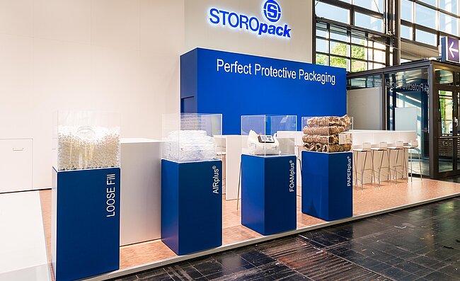 A Storopack trade fair stand with four blue display cases
