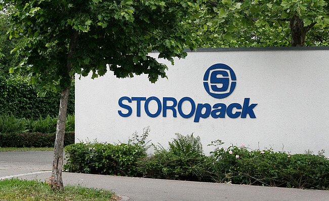 Eine weiße Mauer mit blauem Storopack Logo