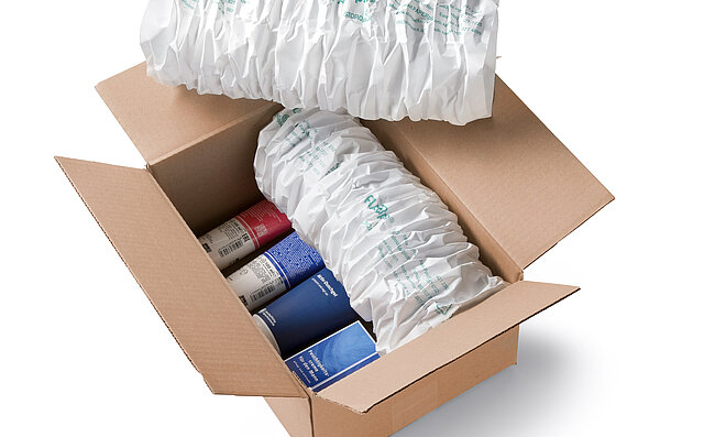 Ein Karton mit Kosmetikprodukten und weißen Papierpolstern